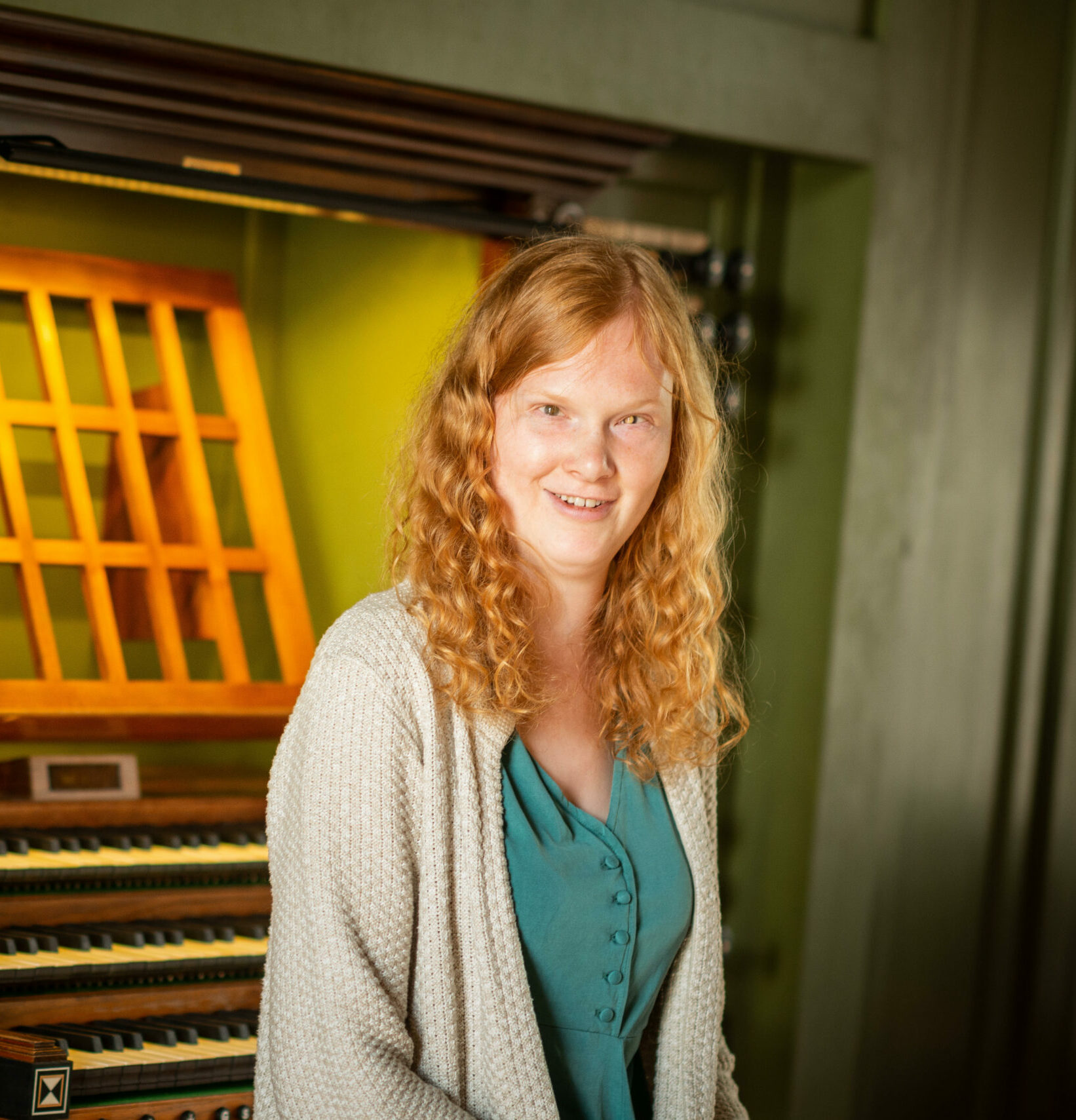 Ein Halbkörper-Portrait von Solveig-Marie Oma mit einer Orgel im Hintergrund.